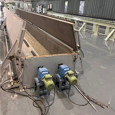 A large fabricated hopper and chute assembly with drive motors